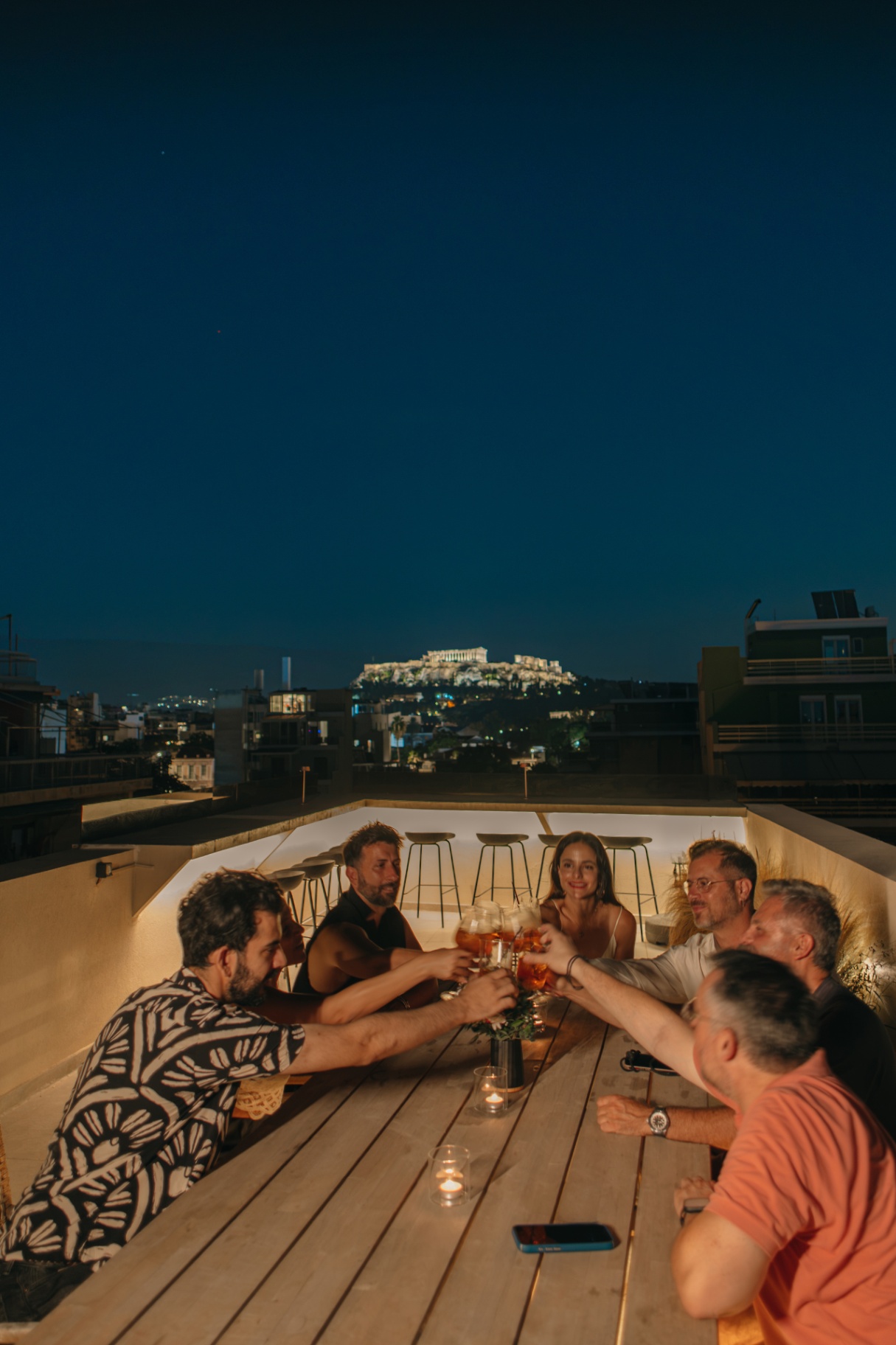 Guests toasting on the rooftop with the Acropolis behind