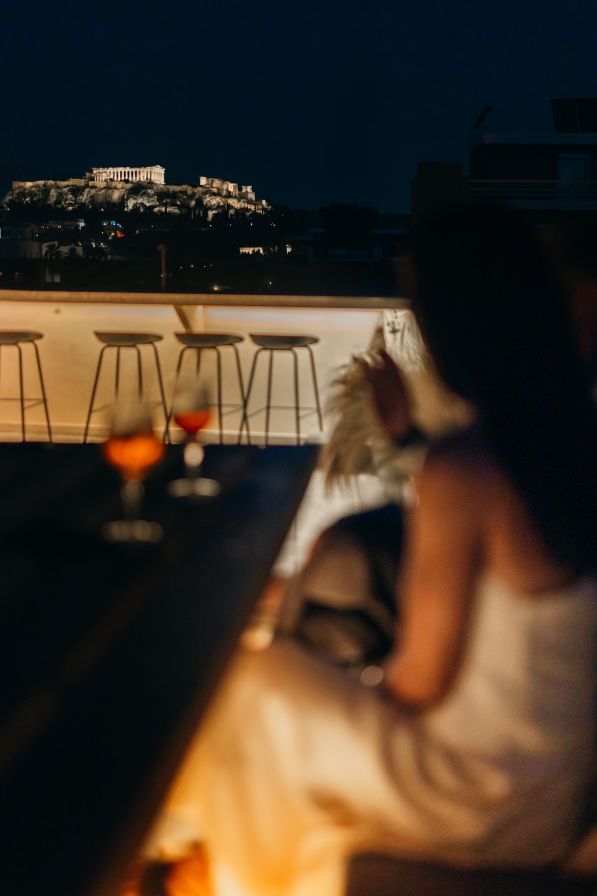 Bar stools facing the Acropolis view in the blue hour